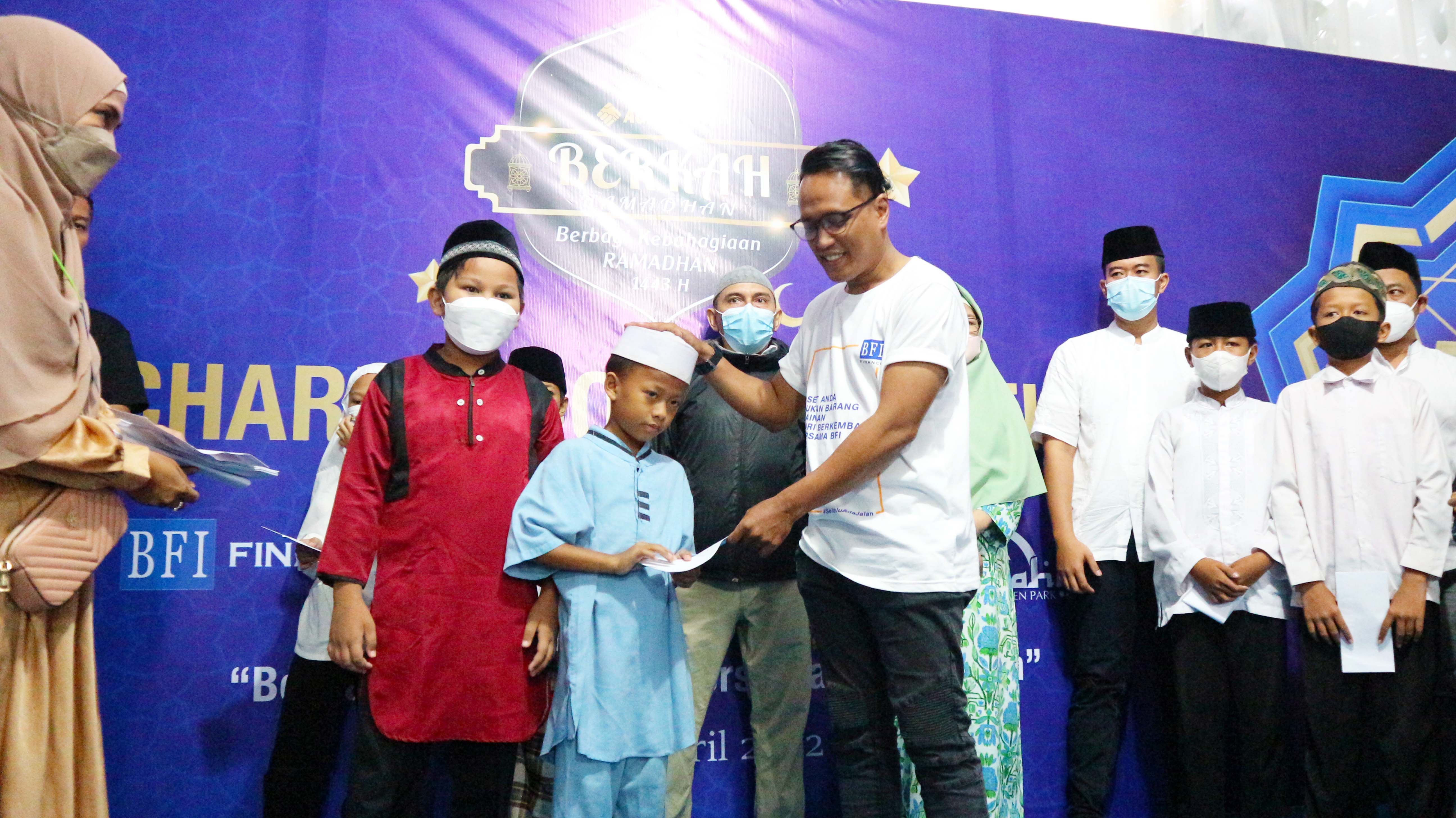 Ade Rifki (Agency Partnership Head BFI Finance) menyerahkan santunan kepada salah satu anak yatim