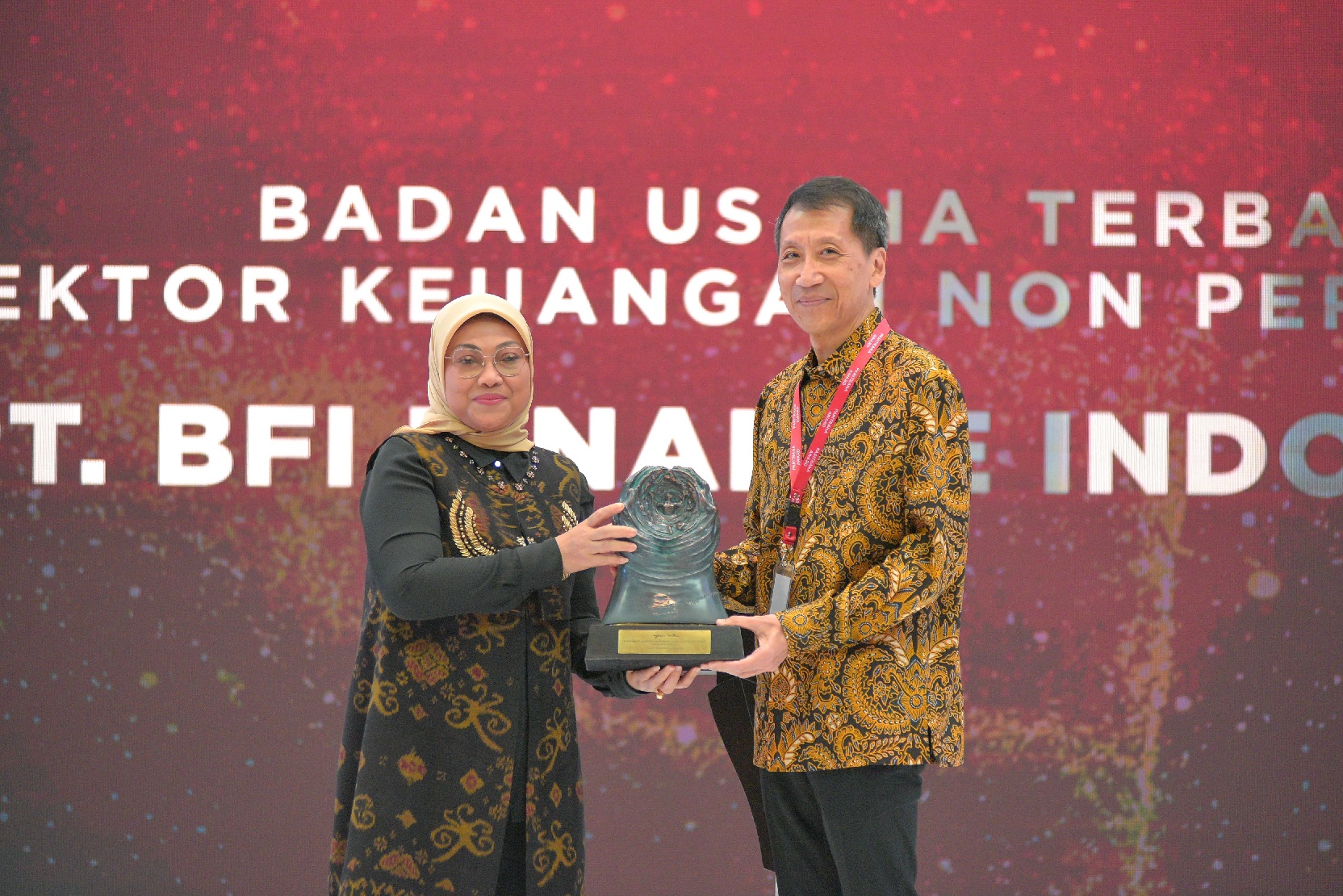 Operational Director of BFI Finance Andrew Adiwijanto receives Paritrana trophy (sculpted by artist I Nyoman Nuarta) from Manpower Minister of Indonesia Ida Fauziyah